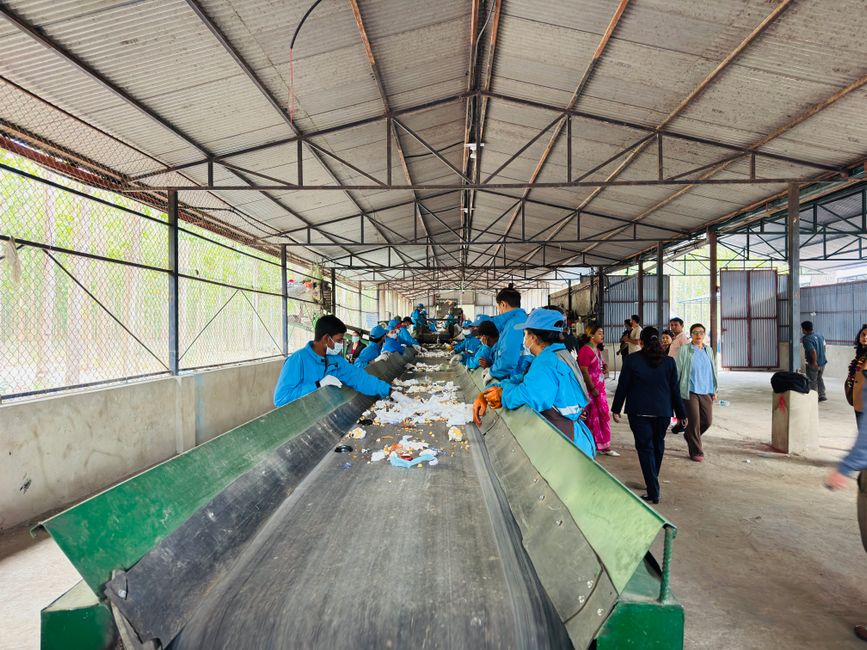 Recycling workers in Butwal, Nepal sorting waste at an indoor facility, promoting sustainability.